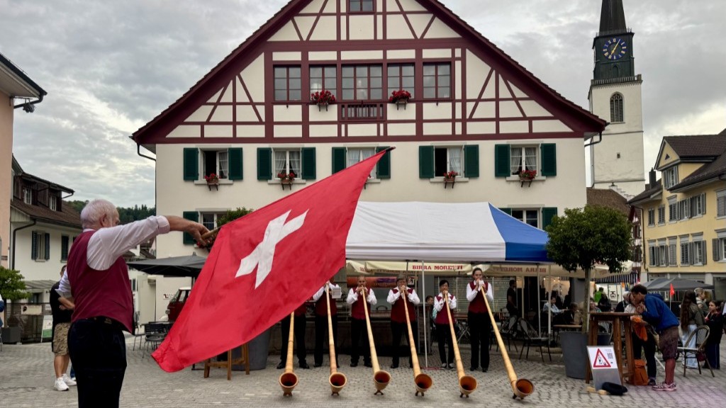 Den Auftakt machen die Alphornbläser samt Fahnenschwinger.