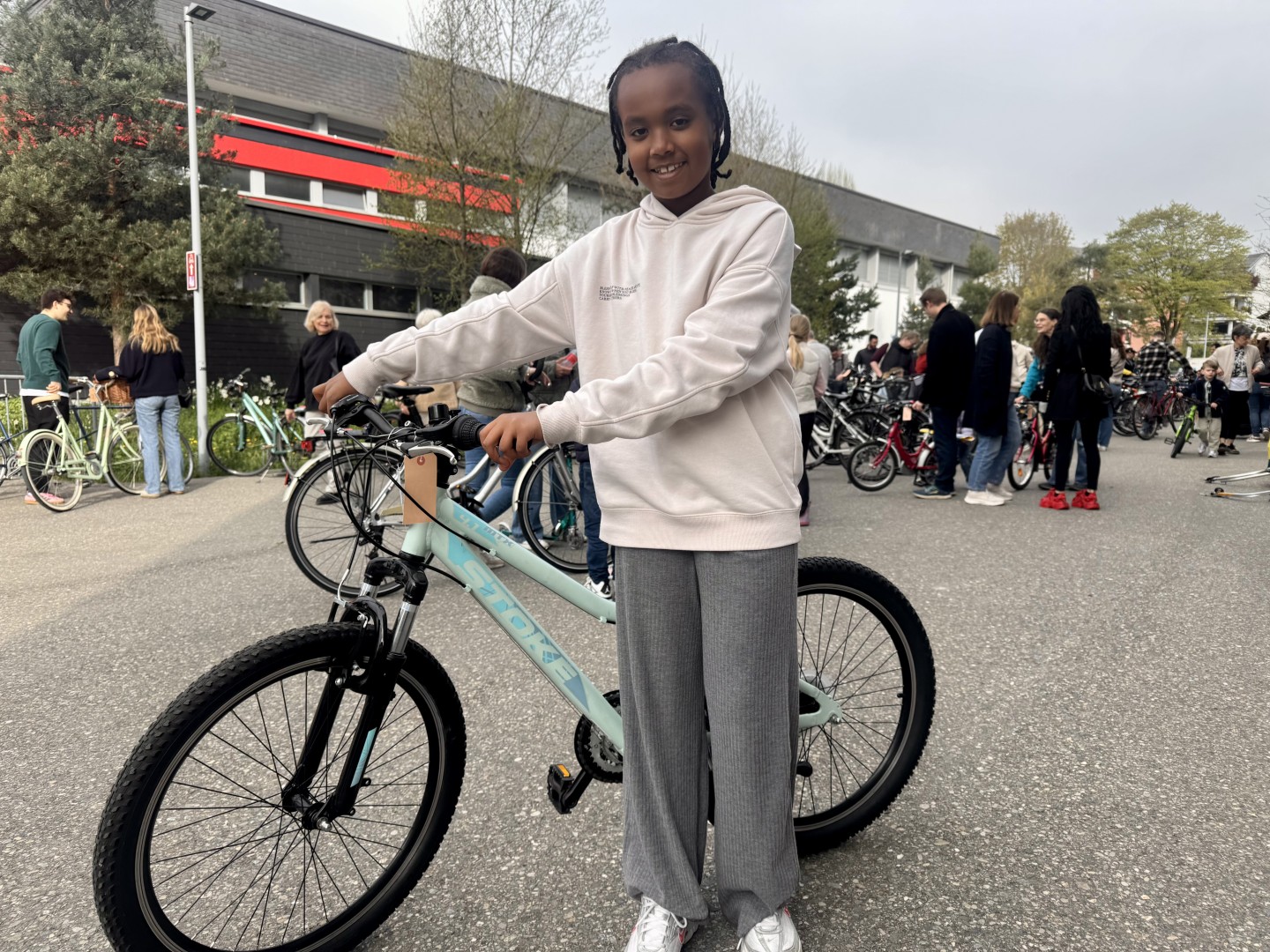 Die achtjährige Sara ist überglücklich mit ihrem neuen mintgrünen Velo.