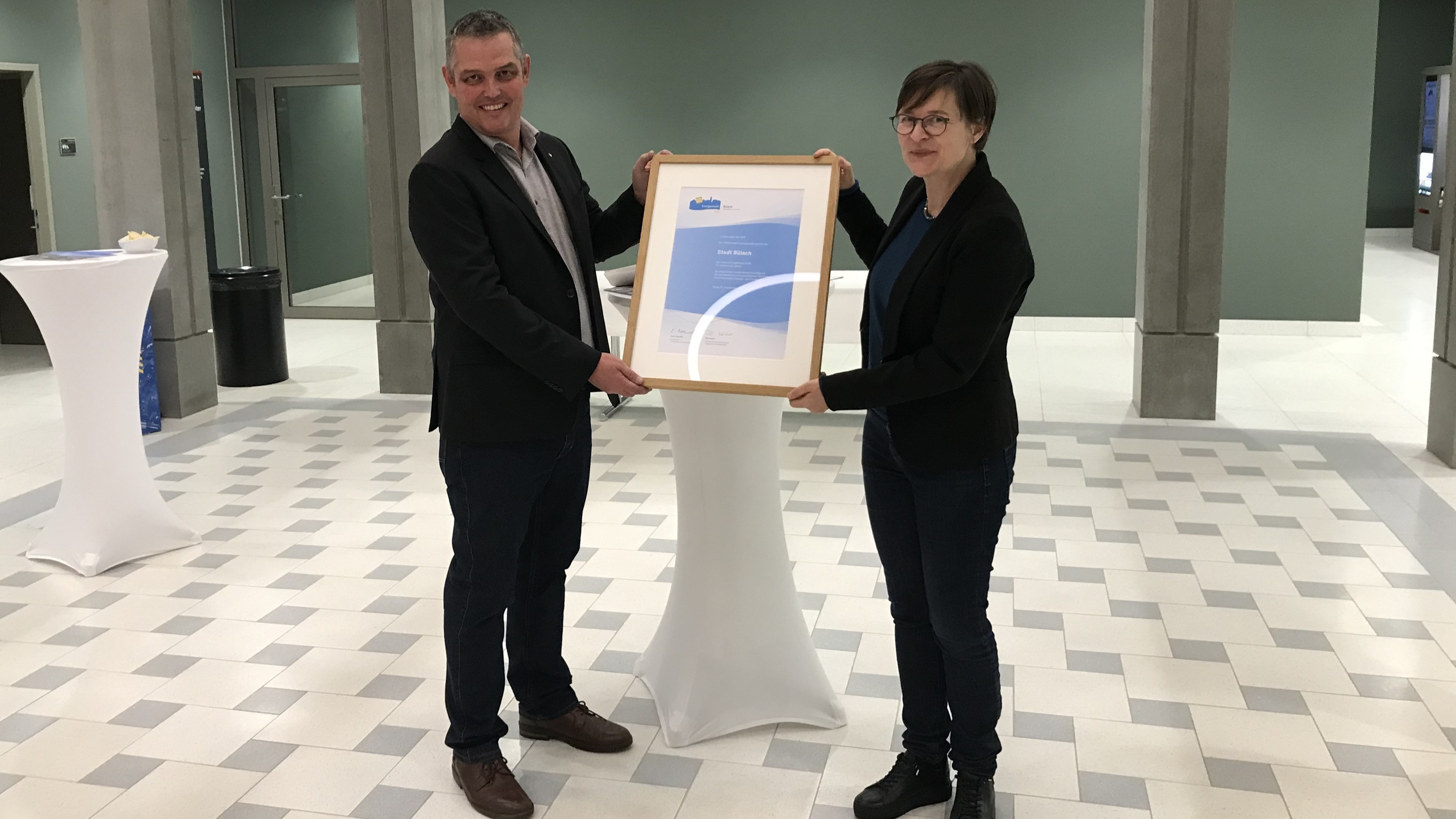 Kathrin Bernath überreicht Stadtrat Andreas Müller das Zertifikat als Energiestadt Gold..